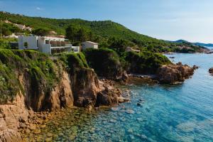 a view of a rocky shoreline with houses and the water at Hotel le Jardin d'Emile in Porticcio