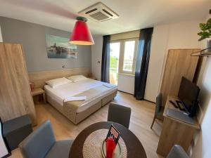 a bedroom with a bed and a table and a television at Villas Arbia - Magdalena by the Beach in Rab
