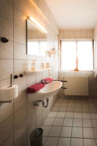 Landgasthof Ritter في فيلينغن شفيننغن: حمام أبيض مع حوض ومرآة