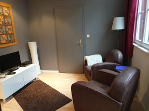 un soggiorno con 2 sedie e una TV di Strasbourg Centre Epine a Strasburgo