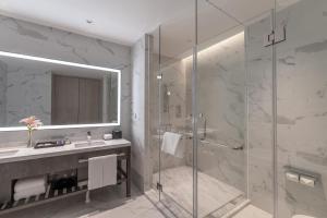 a bathroom with a shower and a sink and a mirror at Hyatt Place Changsha Airport in Changsha