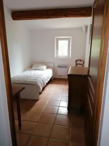 een kleine slaapkamer met een bed en een klein raam bij mas cantarello in Rognes
