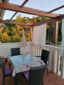 una mesa y sillas en un balcón con vistas a los árboles en Sunshine apartment en Rab