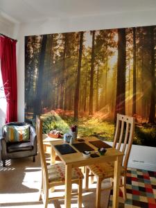 a dining room with a table and a forest mural at The Lakes B and B in Ambleside