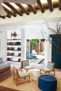 a living room with chairs and a book shelf at Veranda Pointe Aux Biches Hotel & Spa in Trou aux Biches