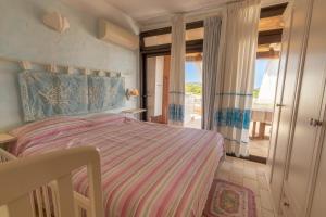 - une chambre avec un lit et une grande fenêtre dans l'établissement Costa Smeralda Holiday Apartments, à Golfo Aranci