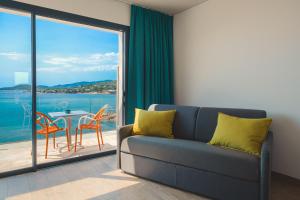 a living room with a couch and a table with chairs at Hotel le Jardin d'Emile in Porticcio