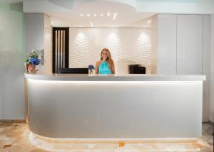 a woman sitting at a counter in a lobby at Hotel Castellucci in Bellaria-Igea Marina