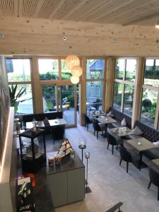 a restaurant with tables and chairs and windows at Hotel Garni Villa Rosengarten in Überlingen