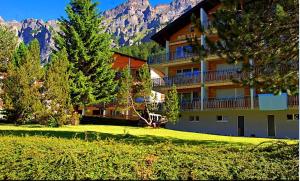 a large building with trees and mountains in the background at Mireille, Appartment 61 in Leukerbad