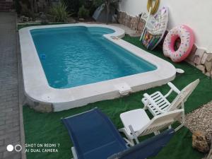una piscina con sillas y un donut en un patio en Rural Olalla, en Villar de Olalla