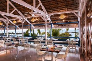 a restaurant with tables and chairs and a view of the ocean at Veranda Pointe Aux Biches Hotel & Spa in Trou aux Biches