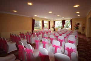 a room filled with white chairs with pink bows at Gipsy Hill Hotel in Exeter