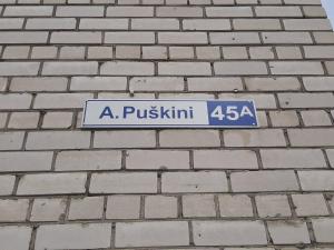 um sinal de rua azul numa parede de tijolos em Piramida Apartments em Narva