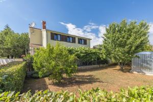 a house with a yard with trees and a fence at Valeria Apartment in Vabriga