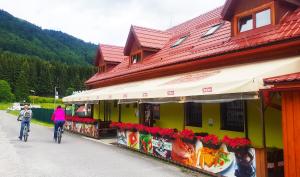 two people riding bikes in front of a building at PATTY Garni in Donovaly