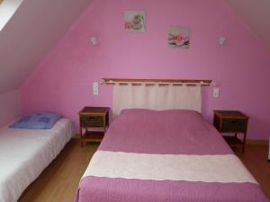 1 dormitorio con 2 camas y pared de color rosa en Gîte Clévacances dans le Finistère, en Scrignac