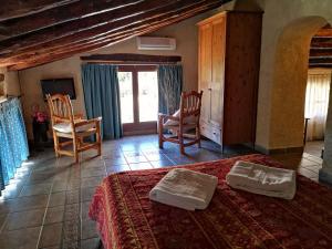 a bedroom with a bed and chairs in a room at Alojamiento Rural Casa Honda in Ayna