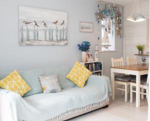 ein Wohnzimmer mit einem blauen Sofa und einem Tisch in der Unterkunft Wendy House in Eastbourne