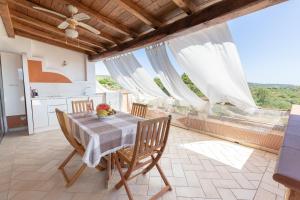 - une cuisine et une salle à manger avec une table et des chaises dans l'établissement Costa Smeralda Holiday Apartments, à Golfo Aranci