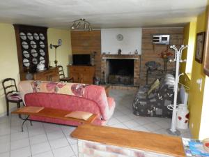 een woonkamer met een bank en een open haard bij Gîte Clévacances dans le Finistère in Scrignac