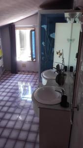 a bathroom with two sinks and a toilet and a window at l orchidee in Hérisson