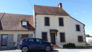 a blue car parked in front of a house at l orchidee in Hérisson