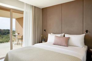 a hotel room with a bed and a balcony at Vincci EverEden in Anavyssos
