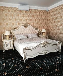 a bedroom with a white bed with two night stands at "Palazzo" in Kostanay