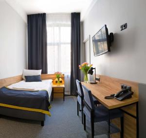 Pokój hotelowy z łóżkiem i biurkiem w obiekcie Hotel Mokotów w Warszawie