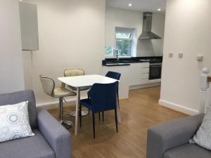 a kitchen and living room with a table and chairs at Beautiful 1 BED Serviced APARTMENT COBHAM Town Centre in Cobham