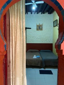 Schlafzimmer mit einem Bett und einem Fenster mit Vorhängen in der Unterkunft PENSION VERGARA , Sevilla in Sevilla