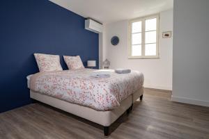 a bedroom with a bed and a blue wall at L'Auberge du Croissant in Rochecorbon