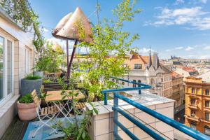 a patio area with a balcony and a balcony view at Mosaic House Design Hotel in Prague