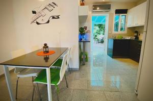 a kitchen and dining room with a table and a guitar on the wall at Iason Seaview home in Latchi in Polis Chrysochous