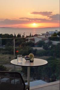a table with a vase on it with the sunset at Vincci EverEden in Anavyssos