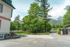 a parking lot with trees and a mountain in the background at TATRYSTAY Apartmány Lomnica in Tatranská Lomnica