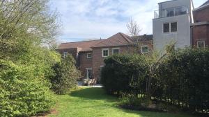 una casa con un patio con arbustos y un edificio en B&B Molen Ter Walle, en Geraardsbergen