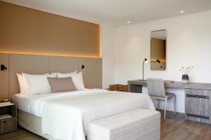 a bedroom with a large white bed and a desk at Vincci EverEden in Anavyssos