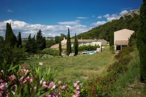 a house in a field with trees and flowers at Château Catherine de Montgolfier B&B in Narbonne