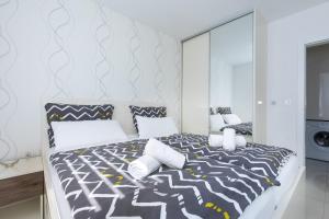 a bedroom with a black and white bed with a mirror at Orfeo in Krk