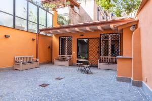 un patio avec des chaises et une table dans un bâtiment dans l'établissement Residenza Palline, à Rome