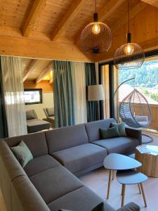 ein Wohnzimmer mit einem Sofa und einem Tisch in der Unterkunft Der Dolomitenhof - Tristach in Lienz