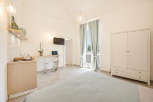 a white kitchen with a white cabinet and a desk at Le Volte Procida Home in Procida
