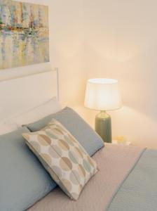 a bedroom with a bed with a pillow and a lamp at Le Volte Procida Home in Procida