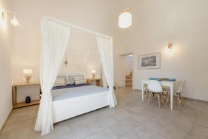 a bedroom with a canopy bed and a table and chairs at Le Volte Procida Home in Procida