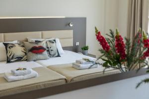 a bedroom with a bed with towels and a mirror at Queens Bay Hotel in Paphos