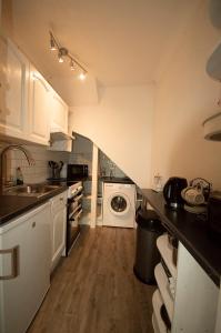 a kitchen with a sink and a washing machine at The garden flat in Torquay