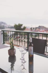 een fles wijn en twee wijnglazen op een tafel bij Fedra - Panoramic Sea View in Nafplio
