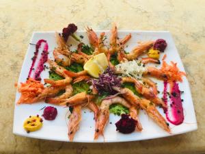 a plate of shrimp and vegetables on a table at Kompleksi Turistik EDIR in Orikum